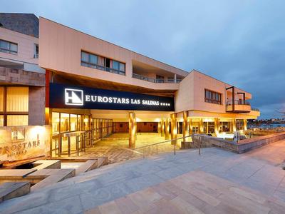 Wejście do nowoczesnego hotelu o zmierzchu z oświetlonymi fasadami i dostępem z ulicy.