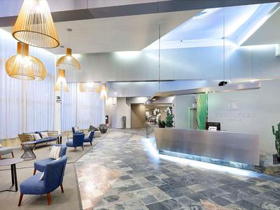 Jasne lobby hotelowe z nowoczesnym designem, wygodnymi fotelami i recepcją.