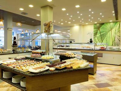 Strefa bufetu z różnorodnym jedzeniem i nowoczesnym wnętrzem w hotelu.