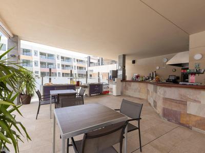 Zadaszony taras z stołami, krzesłami i barem w nowoczesnym hotelu.