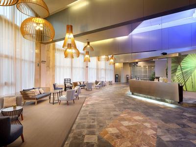 Nowoczesna i jasna strefa lounge w hotelu z wygodnymi miejscami do siedzenia i ciepłym światłem.