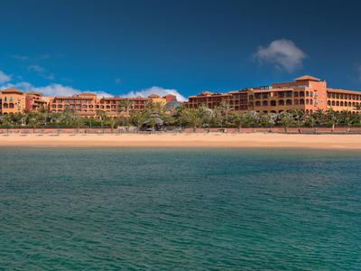 Großes Resort am Strand mit blauem Himmel und klarem Meer.