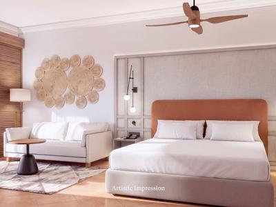 Modernes Hotelzimmer mit King-Size-Bett, Sofa, Deckenventilator und warmem Holzboden.
