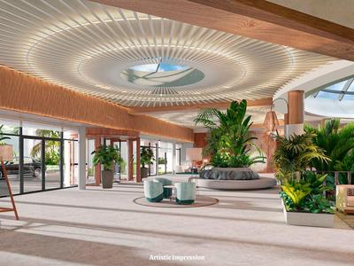 Atrio dell'hotel luminoso con grandi piante e moderno design circolare del soffitto.