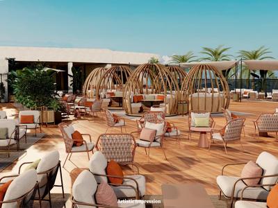 Lounge all'aperto con poltrone in vimini, letti rotondi e terrazza in legno con sole.