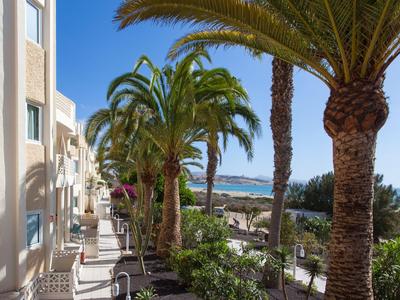 Uitzicht op hotelbalkons met palmbomen en strand op de achtergrond op een zonnige dag