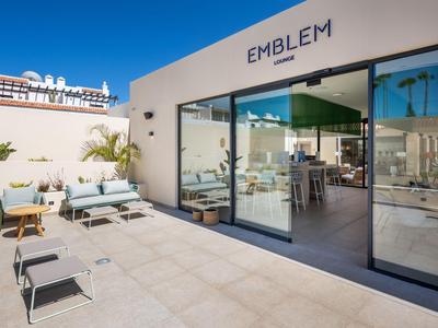 Moderner Hotel-Loungebereich mit Terrasse, Sitzgelegenheiten und Blick auf das Meer.