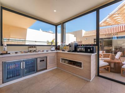Moderne Küchenzeile mit Blick auf Terrasse und Himmel in einer Hotelunterkunft.