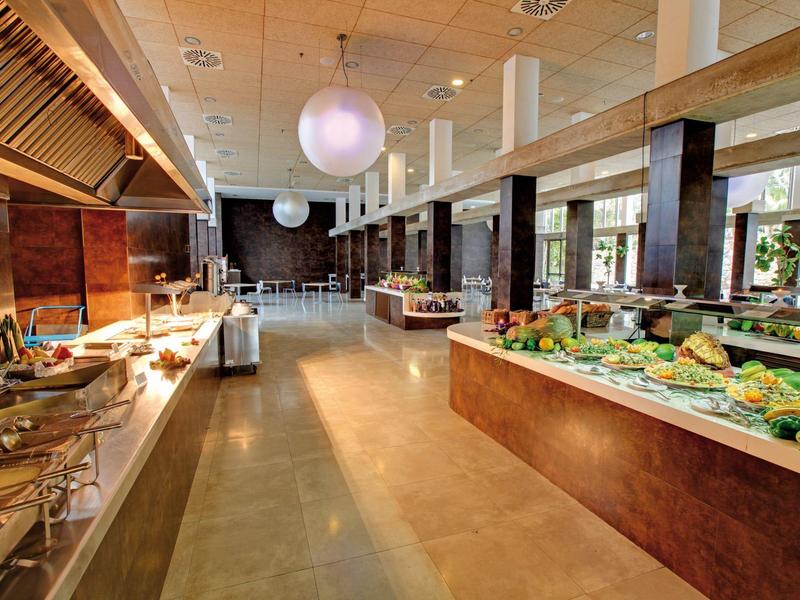 Ruime buffetzaal met diverse voedselstations en moderne verlichting in een hotelrestaurant.