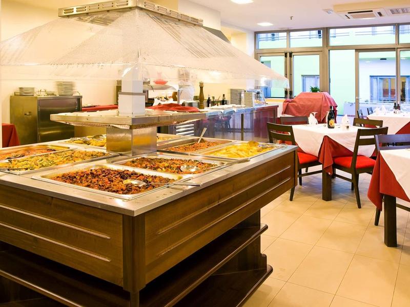 Well-lit dining area with buffet and set tables in a hotel.