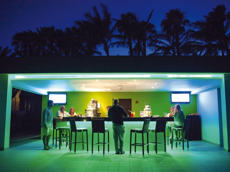 Moderne buitenbar 's nachts met verlichte bar en zitplaatsen.