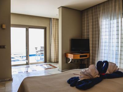 Camera d'hotel con letto, TV a parete e balcone con vista sul mare