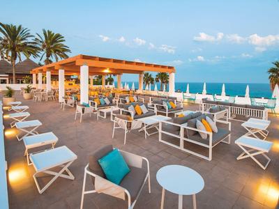 Modern terrace with comfortable seating and sea view at sunset.