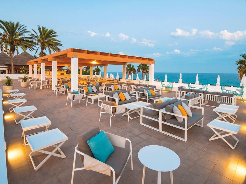 Terrasse ouverte avec sièges et vue sur la mer sous un ciel bleu