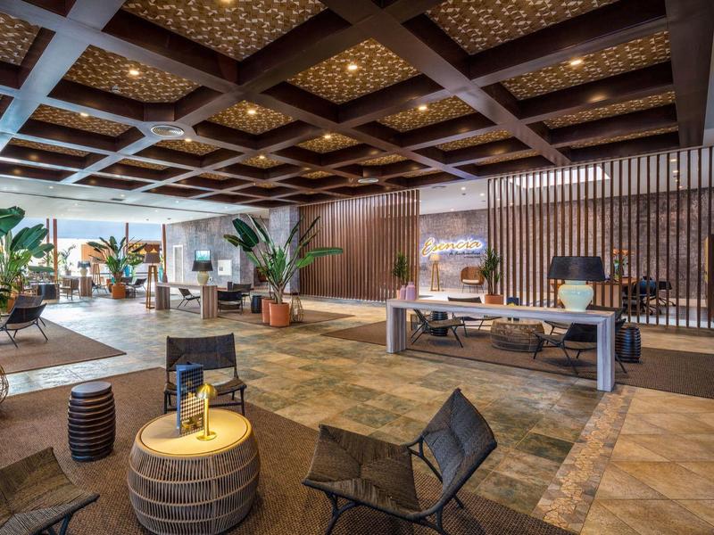 Hall d'hôtel moderne avec sièges spacieux, décoration végétale et éclairage élégant