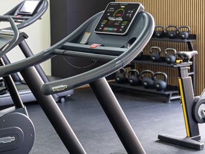 Tapis roulant e manubri in una palestra moderna con pannelli in legno.