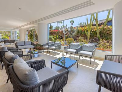 Helle Lounge mit modernen Sitzmöbeln und großem Fensterblick auf Gartenlandschaft.