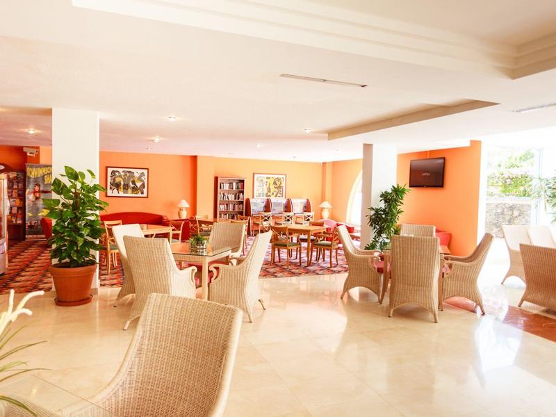 Bright, spacious hotel lobby with wicker furniture and large windows.