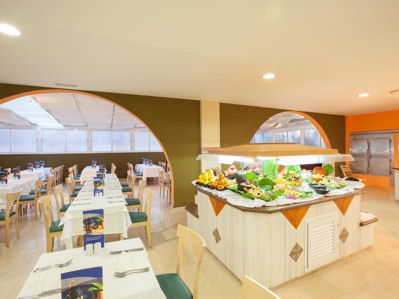 Bright dining area with buffet and set tables in a hotel restaurant.