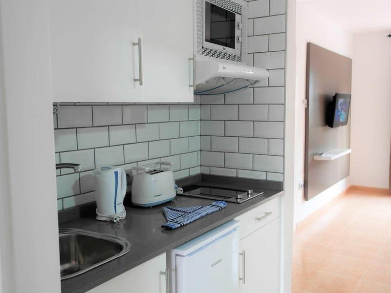 Compact kitchenette with microwave, kettle, and toaster in a hotel room.