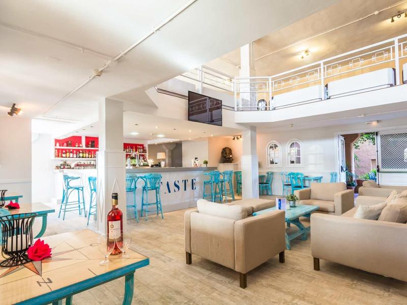 Bright hotel room with comfortable sofas, blue chairs, and a reception desk.