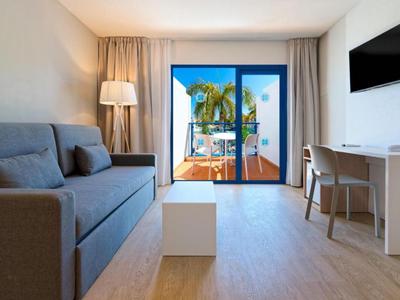 Modern eingerichtetes Hotelzimmer mit Balkon und Blick aufs Meer.