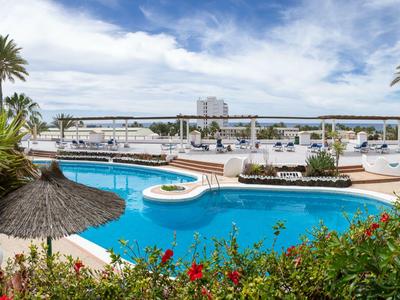 Zona piscina con palme e vista sulla marina sotto un cielo blu