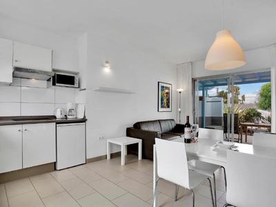 Bright, modern apartment with kitchenette, dining area, and balcony overlooking the neighborhood.