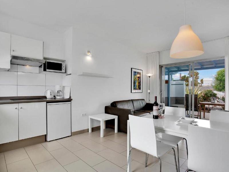 Bright, modern apartment with kitchenette, dining area, and balcony overlooking the neighborhood.