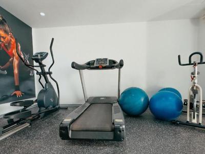 Gimnasio del hotel con cinta de correr, bicicleta estática, elíptica y pelotas de ejercicio.