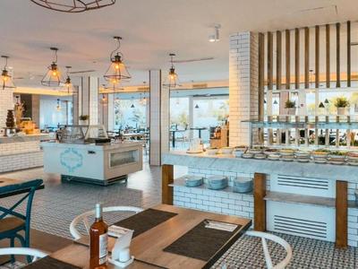 Restaurante moderno y luminoso con grandes ventanas y vistas al mar.