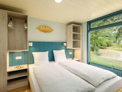 Cozy double room with two beds and large window overlooking nature.