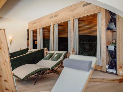 Przytulny pokój wypoczynkowy z leżakami i dużymi oknami w strefie wellness.