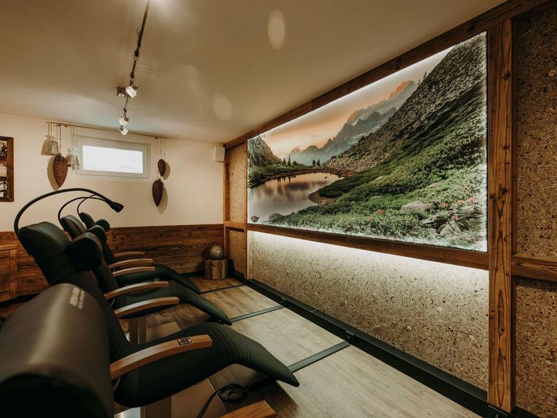 Przytulny pokój relaksacyjny z fotelami do leżenia i dużym oknem z widokiem na góry.