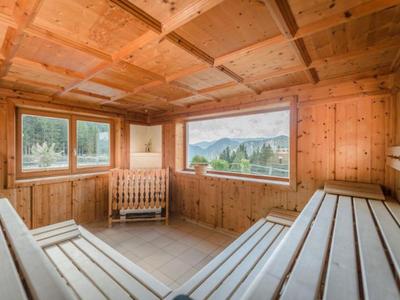 Sauna en bois avec deux bancs, fenêtres et vue sur les montagnes