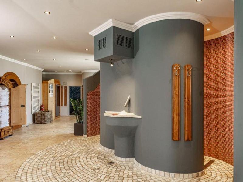 Couloir d'hôtel moderne avec murs courbes, lavabo et accents en bois élégants.