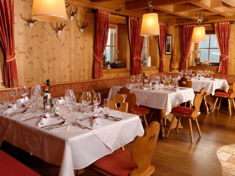 Restaurant confortable avec mobilier en bois et tables dressées sous un éclairage chaleureux.
