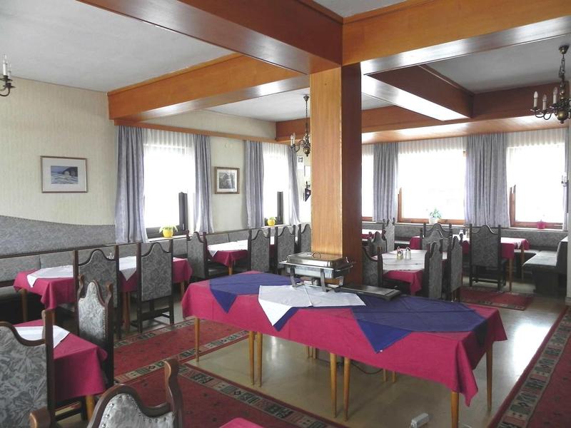 Elegancka sala jadalna z nakrytymi stolikami, drewnianymi belkami i dużymi oknami w hotelu.