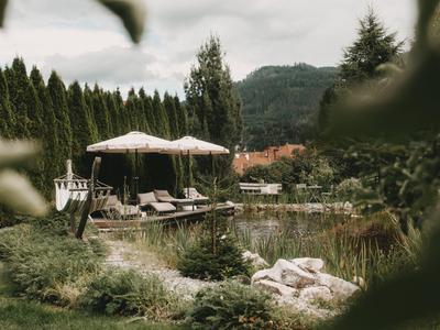Relaxing outdoor area with sun umbrellas, lounge chairs, and views of trees and mountains.