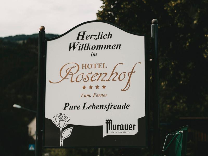 Welcome sign with "Hotel Rosenhof" text in elegant script, set against trees.