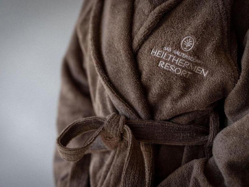 Albornoz marrón con logo del hotel, hecho de tela suave con cinturón para atar