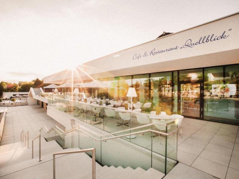Terraza moderna de un hotel con mesas y sombrillas al atardecer