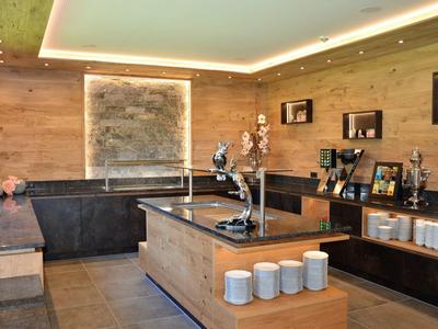 Bar d'hôtel moderne avec boiseries, cascade décorative et comptoir accessible.