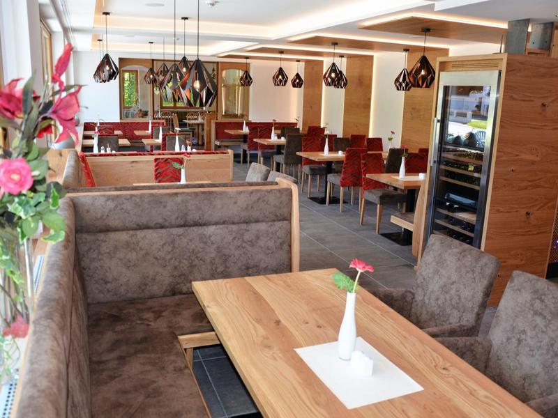 Espace restaurant d'hôtel lumineux avec banquettes confortables et détails en bois.