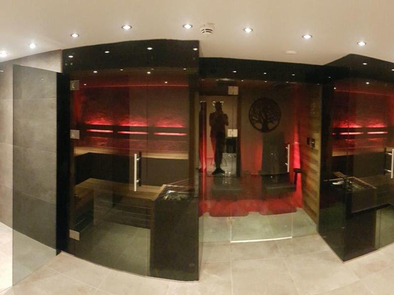 Espace bien-être moderne avec sauna et salle de détente en tons rouges chauds