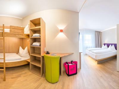 Helles Hotelzimmer mit Etagenbett, Doppelbett und moderner Einrichtung