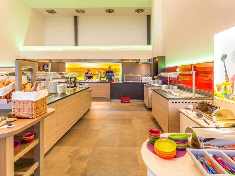 Hell beleuchteter Frühstücksbereich mit einer Vielzahl von Speisen und Getränken in Buffetform.