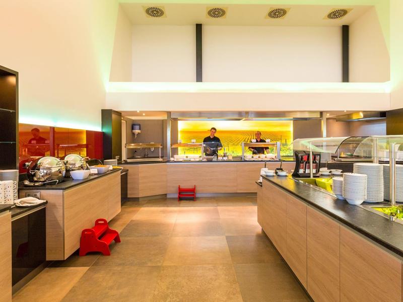 Moderner Frühstücksbereich mit Buffet und Arbeitsfläche in warmen Farben