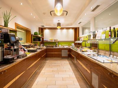 Buffetbereich mit verschiedenen Speisen, Getränken und Kaffeemaschine in einem Hotel.