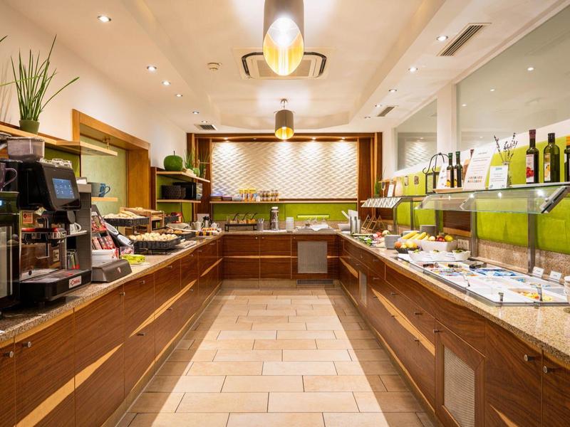 Buffetbereich mit verschiedenen Speisen, Getränken und Kaffeemaschine in einem Hotel.